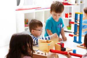 Montessori children practicing sorting activities to develop cognitive and motor skills.