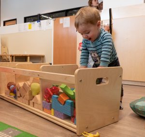 Child using Montessori sandpaper letters to practice early literacy and phonetic sounds.